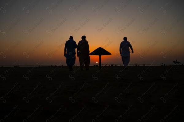 Silhouette of people walking on the beach in the evening at Al Seif Beach in Jeddah, Saudi Arabia