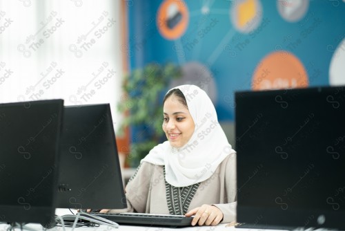 فتاة سعودية تقوم بتعابير مختلفة في غرفة اجهزة الحاسب الآي ، تستخدم الحاسب الآلي ، تظهر شاشات الكمبيوتر.