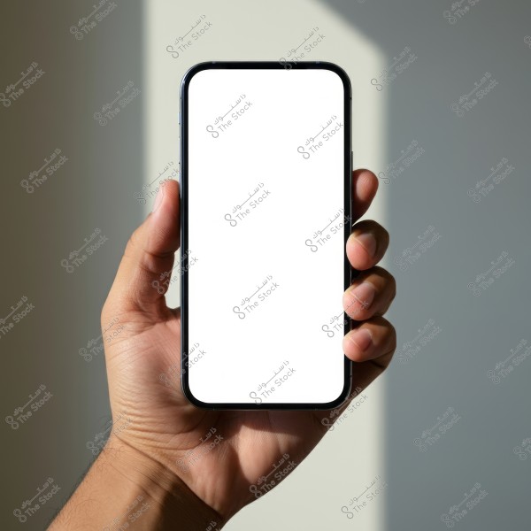 An image of a hand holding a smartphone with a completely blank white screen. The fingers are clearly shown gripping the sides of the phone. The background is partially blurred with soft shadows visible.