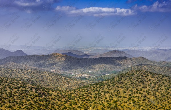 A snapshot of a village on a mountain slope located on Mount Daqqa in Al-Shifa in Taif Governorate, showing the sky overcast and clouds, Taif Mountains, nature in Saudi Arabia