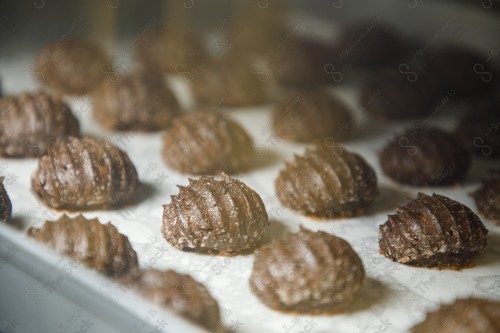 A group of Shami dates with chocolate on butter paper in an oven tray