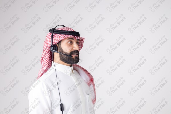 بورتريه رجل سعودي يلبس سماعة الرأس ويقوم بالتواصل عبر السماعة - خدمة العملاء ، مكالمة هاتفية