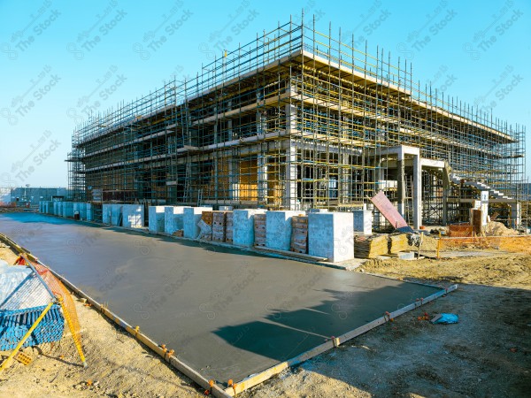 A construction site with a large building in the background. multi-storey building. A construction site with scaffolding and a large building in the background.