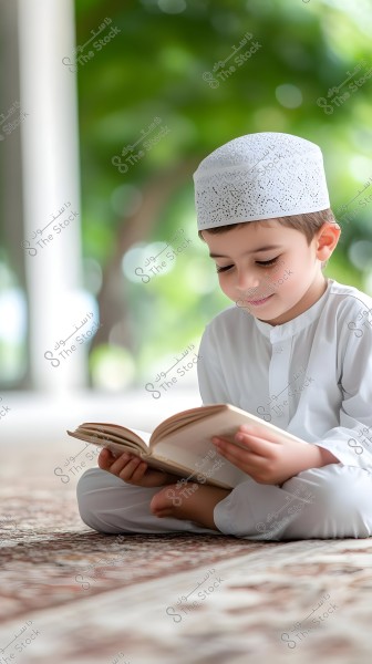 An image of a young boy sitting on the floor in a meditative pose, wearing a white traditional outfit and a white cap, focused on reading a book. The background is blurred with some trees visible, giving a sense of calm and natural beauty.