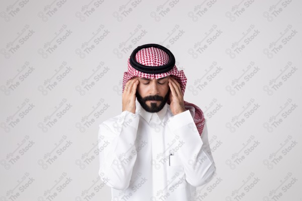 بورتريه رجل سعودي يقف على خلفية بيضاء ويظهر تأثير الصداع