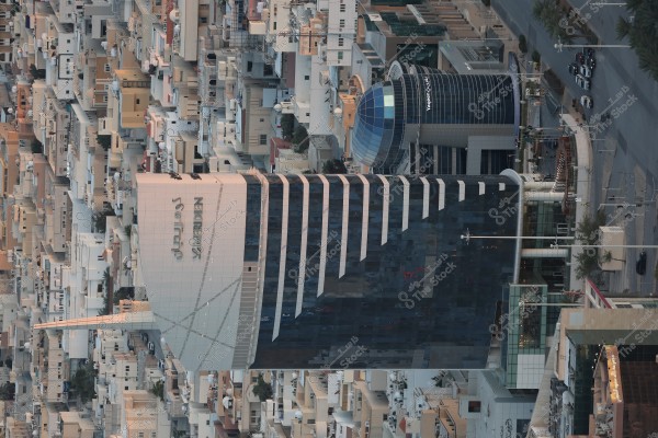 An aerial view of the \"Le Meridien\" and \"Al Saad Tower\" buildings, showcasing modern architectural design. The buildings are surrounded by low-density residential structures, illustrating the harmony between new and surrounding buildings in the city.