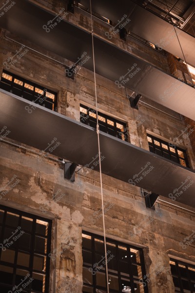 Image of an old concrete wall with glass windows and metal sheet spanning across the wall.