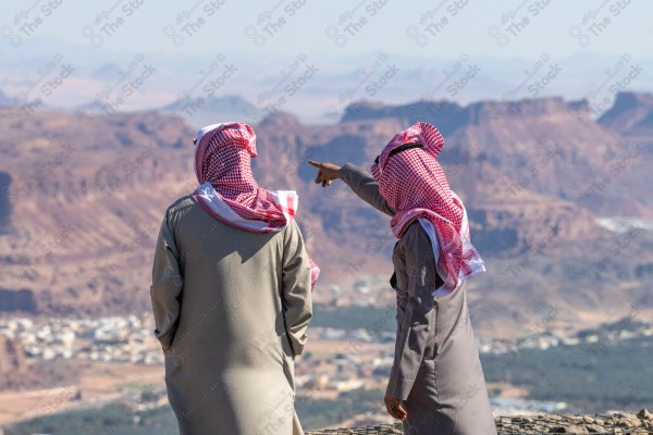 An aesthetic shot of people at the highest mountain peak in Al-Ula Governorate, Saudi Arabia, tourist places in Saudi Arabia, green palm tree farms.