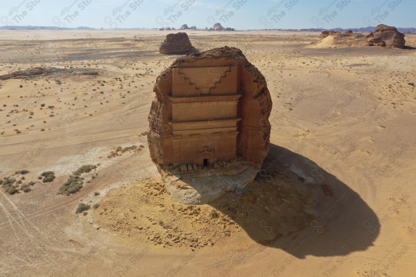 An aerial shot of Al-Farid Palace in Al-Ula Governorate, houses carved into the mountains, Mada’in Saleh, a series of rocky mountains, tourism in Saudi Arabia.