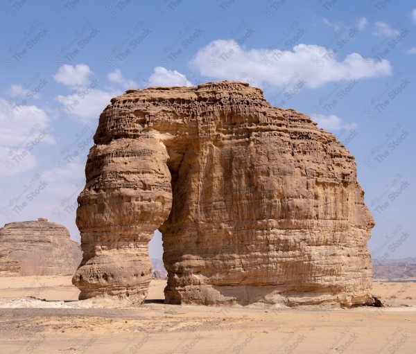 لقطة جمالية لجبل الفيل بوسط الصحراء في العلا وتظهر السماء شبه صافية نهارًا، السياحة في العلا