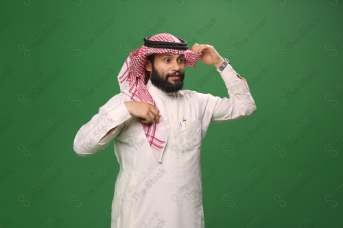 بورتريه رجل سعودي يرتدي الزي الرسمي التقليدي على خلفية خضراء يقوم بعمل اشارات بيديه وهو مبتسم ، حزين، غاضب، صور تذكارية ، توثيق لحظة سعيدة