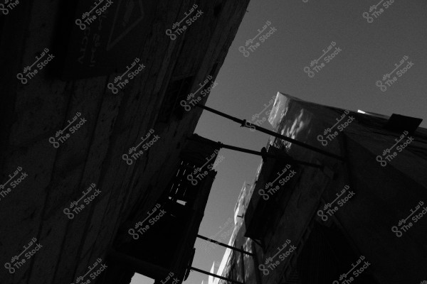 A black and white image showing an old building with traditional Arabic architectural details under an open sky.