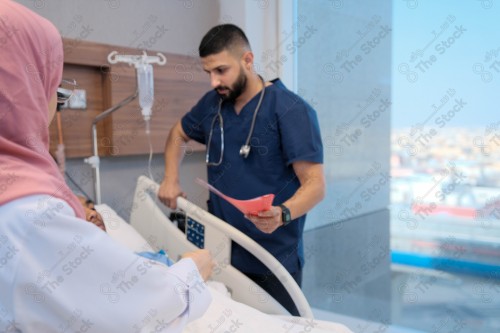 Saudi female doctor and paramedic in medical uniform and examining and applying nutritional solution, medicine and health care