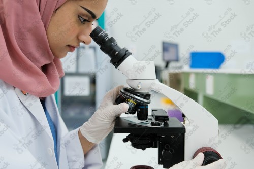 Saudi doctor in a hospital, working in a laboratory that analyzes a sample on a microscope, working in the health sector, providing medical consultations and health services, medicine and health care