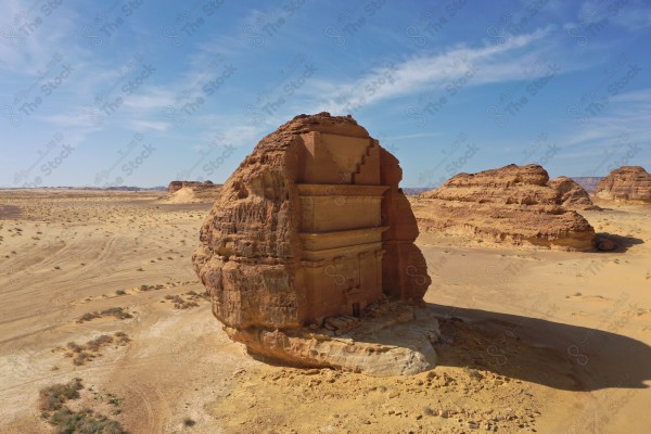 An aerial shot of Al-Farid Palace in Al-Ula Governorate, houses carved into the mountains, Mada’in Saleh, a series of rocky mountains, tourism in Saudi Arabia.