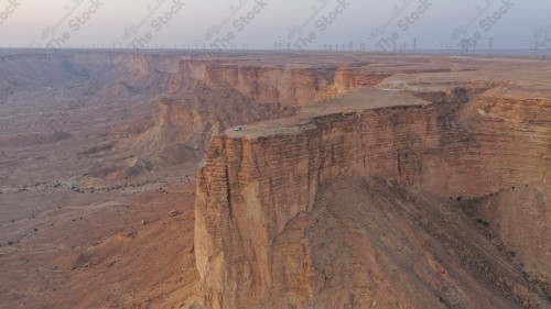 لقطة جوية لمجموعة سياح على جبل من جبال طويق المسمى بحافة العالم. سلسلة من الجبال الصخرية