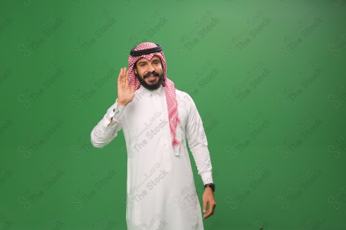 بورتريه رجل سعودي مبتسم يرتدي الزي السعودي التقليدي يلقي التحيّة على أحدهم