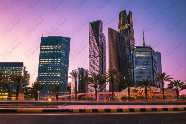 A snapshot showing the buildings and landmarks of the King Abdullah Financial Center in the city of Riyadh, in front of which is a group of residential houses and the clear sky appears.