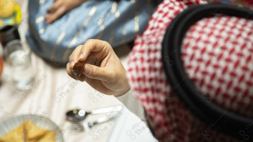 فطور عائلة سعودية برمضان ، رجل يأكل تمر وقت الأذان