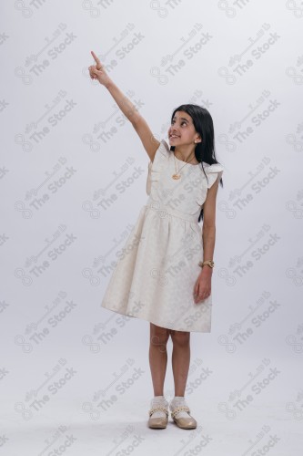 Portrait of a Saudi girl on a white background making gestures with her hands while smiling, souvenir photos, documenting a happy moment, Eid candy, Eid gifts, Eidiyat