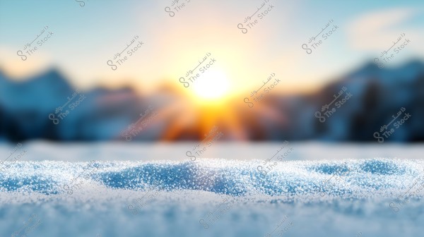 An image showing a natural scenery with a snow-covered surface in the foreground, with bright sun rays setting behind a blurred mountain range in the background. The clear sky transitions between blue and orange hues due to the sunlight reflection.