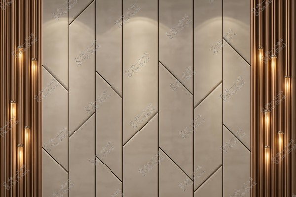 The wall features a modern design composed of interlocking panels with various geometric angles. The panels are in a neutral beige color, flanked by gold-colored metallic rods on both sides. Sleek tubular lights hang from the ceiling between the rods, adding a warm glow to the space.