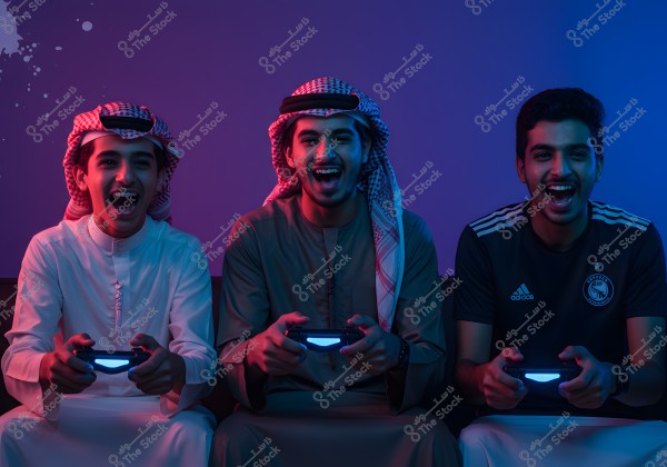 A photo of three young men sitting on a couch playing with game controllers. The two on the left are wearing traditional Arabian attire, including a thobe and a ghutra, while the young man on the right is wearing a dark sports jersey. The room is lit with purple and blue neon lights, creating an energetic and fun atmosphere. All appear happy and smiling as they play.