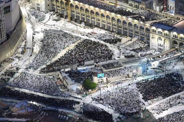 An aerial view of the Grand Mosque in Mecca during the Hajj season, where a large gathering of pilgrims is performing religious rituals.