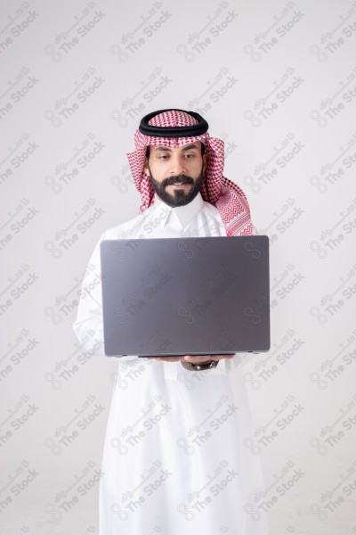 Portrait of a Saudi man holding a laptop and making different expressions, customer service, and communication.