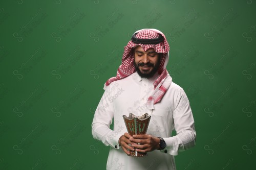 بورتريه رجل سعودي يرتدي الزي السعودي التقليدي يحمل المبخرة