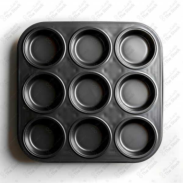 Metal muffin tray with nine holes on a white surface. by AI