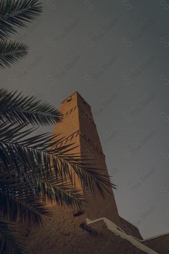 A shot of the minaret ( beacon ) of a Najdi mud mosque, a mosque built of mud, a clear sky.