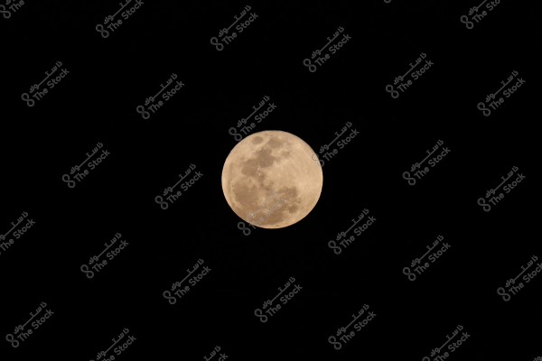 Image of a full moon in the night sky, clearly visible against the dark background. The surface details of the moon, including spots and shadows, are clearly seen.