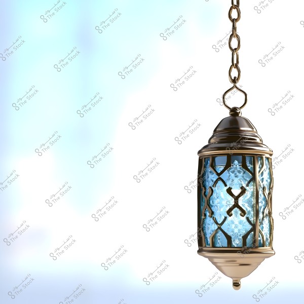 A traditional decorative lantern hanging by a chain, featuring a golden metallic frame and ornate blue glass. The lantern is set against a softly lit background with blue and white gradients, creating a calm and pleasant atmosphere.