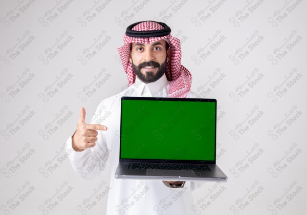 Portrait of a Saudi man holding a laptop, pointing at the laptop and making different expressions - green screen