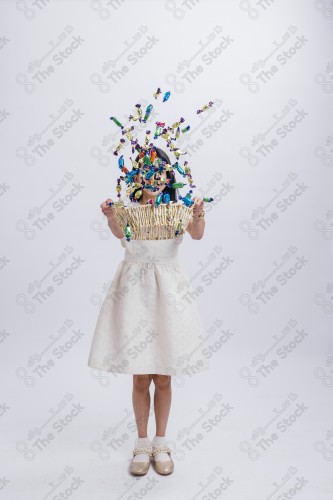 Portrait of a Saudi girl on a white background making gestures with her hands while smiling, souvenir photos, documenting a happy moment, Eid candy, Eid gifts, Eidiyat