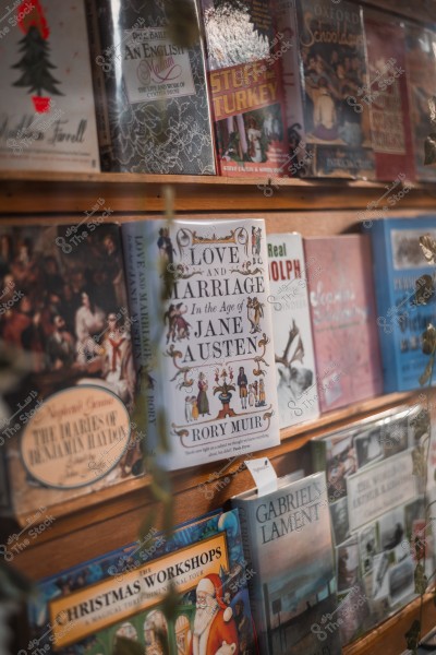 A collection of books displayed on a bookshelf in a bookstore, including a book titled "Love and Marriage in the Age of Jane Austen".