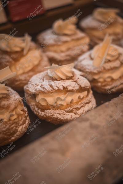 A collection of French pastries topped with powdered sugar and white cream.