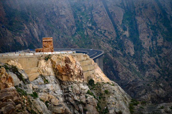 An aesthetic shot of a road in the Taif Mountains in Saudi Arabia showing a clear sky during the day, mountain heights, a series of mountains