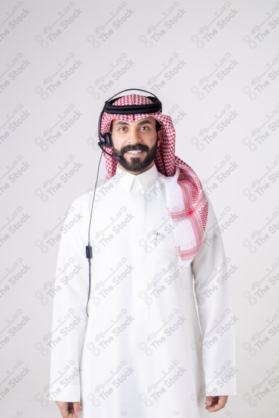 بورتريه رجل سعودي يلبس سماعة الرأس ويقوم بالتواصل عبر السماعة - خدمة العملاء ، مكالمة هاتفية