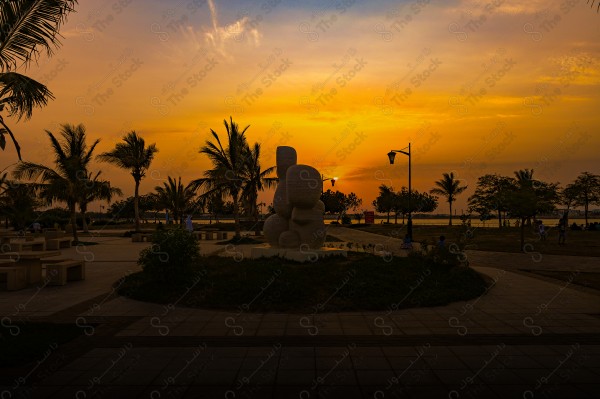 A shot of Jeddah waterfront during sunset showing the sky in orange, the city of Jeddah, rivers and seas.