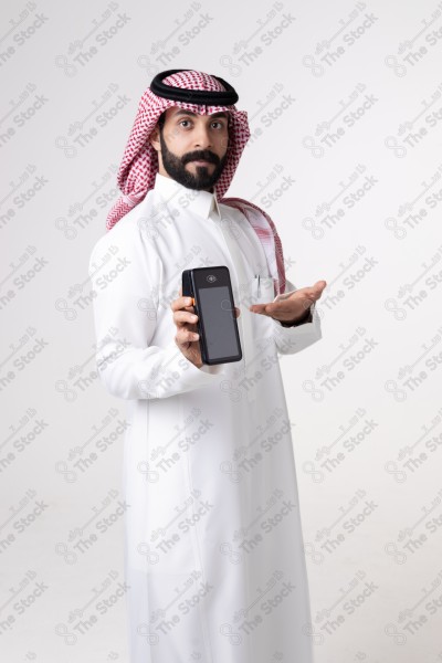 Portrait of a Saudi man holding an automatic payment device and a card and making different expressions