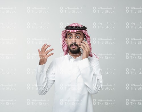 رجل سعودي يقوم بإشارات وهو يتحدث على الهاتف