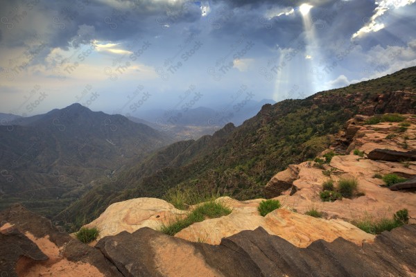 Aerial shot of a series of rocky mountains at sunset and the clouds overlapping between them, nature in Saudi Arabia, sunset