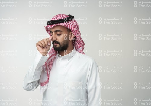 رجل سعودي يرتدي الزي السعودي الرسمي يشير بيده بحرف من حروف لغة الإشارة