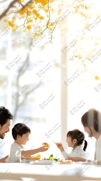 An image of a family of four sitting at a white dining table in a brightly lit setting with branches of yellow flowers hanging in the background. A man and a woman are seated on either side with two smiling children eagerly exchanging food. The children are dressed in white, creating a comfortable and homely atmosphere.
