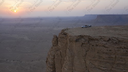 لقطة جوية لمجموعة سياح على جبل من جبال طويق المسمى بحافة العالم. سلسلة من الجبال الصخرية