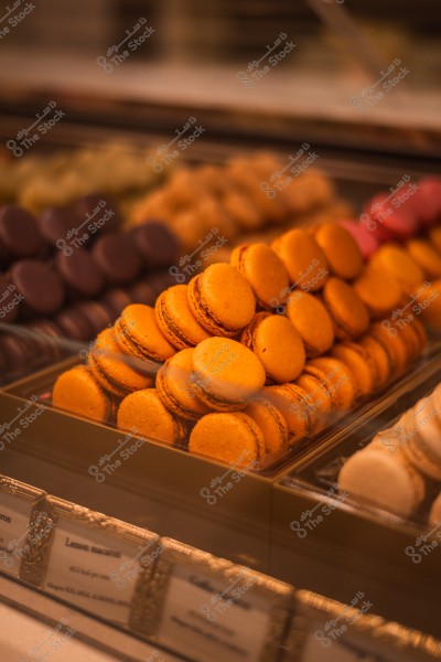 صورة لمجموعة من حلوى الماكرون متعددة الألوان معروضة في واجهة محل حلوى.