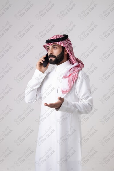 بورتريه رجل سعودي يحمل هاتف ويقوم بمكالمة هاتفية بتعابير مختلفة