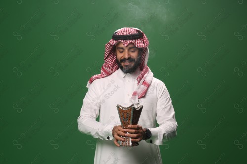 بورتريه رجل سعودي يرتدي الزي السعودي التقليدي يحمل المبخرة